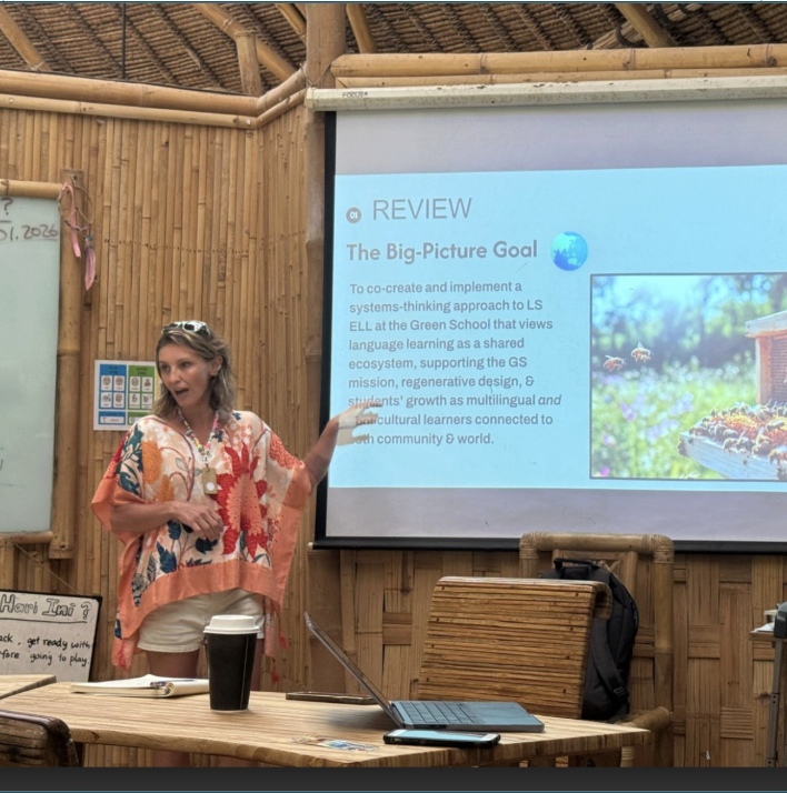 Teacher presenting slideshow in bamboo-walled classroom