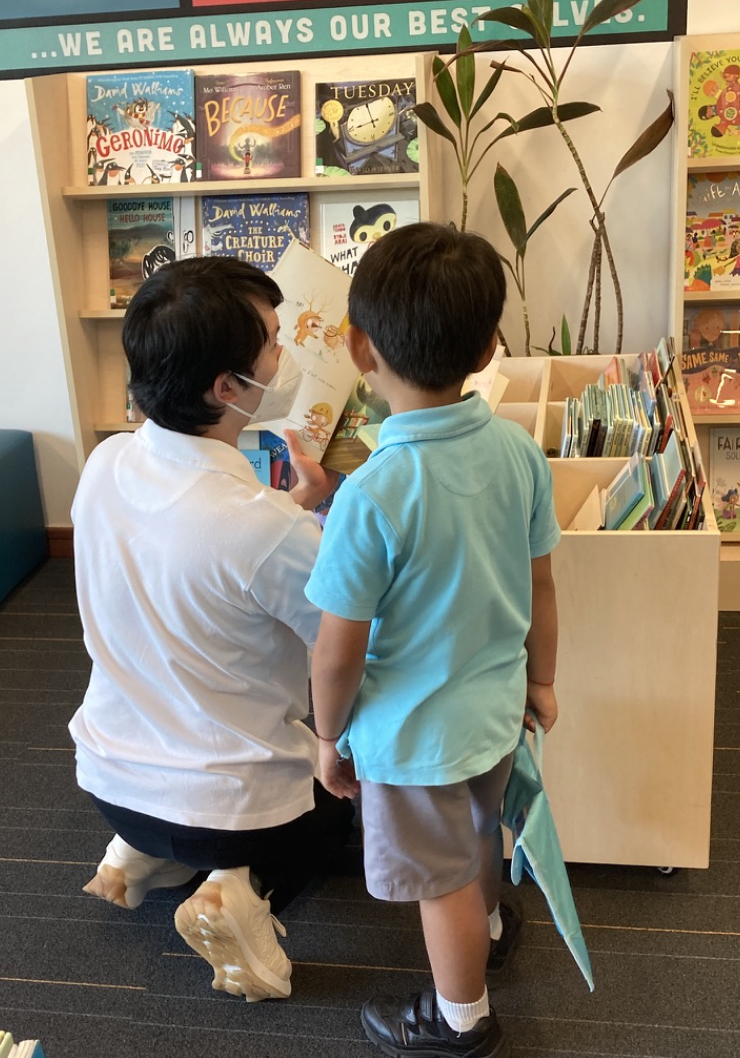 Adult reading book to child in bookstore