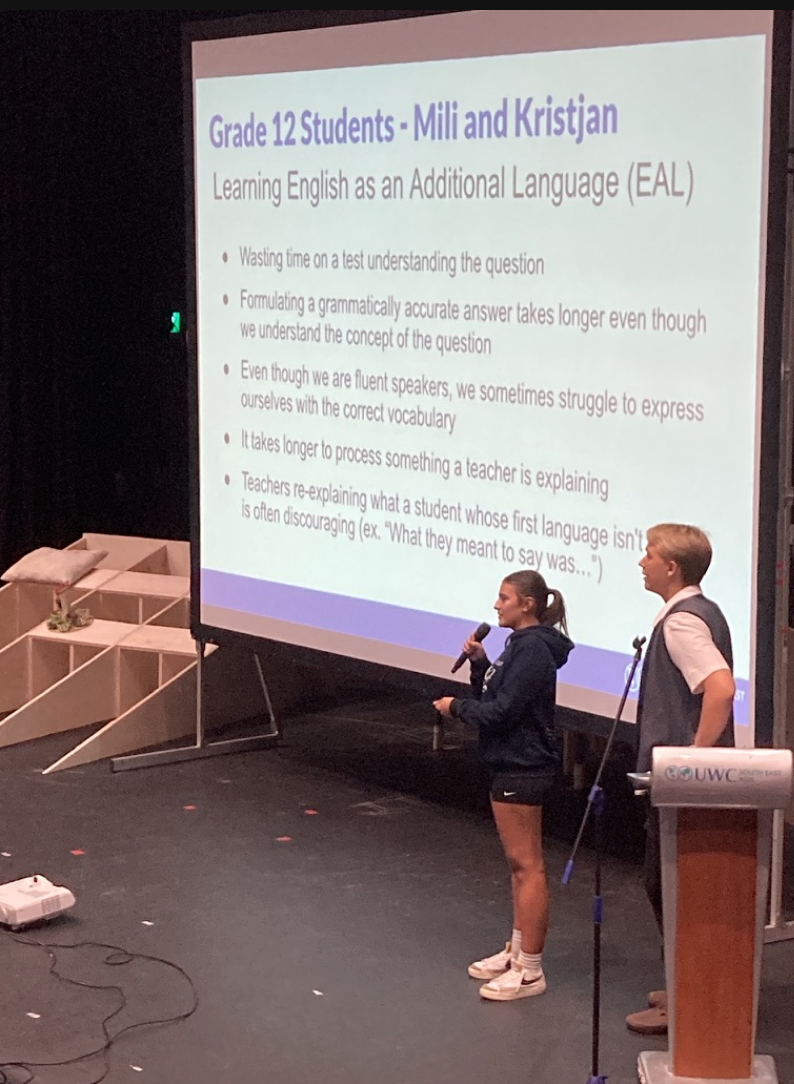 Two students presenting on stage with slide