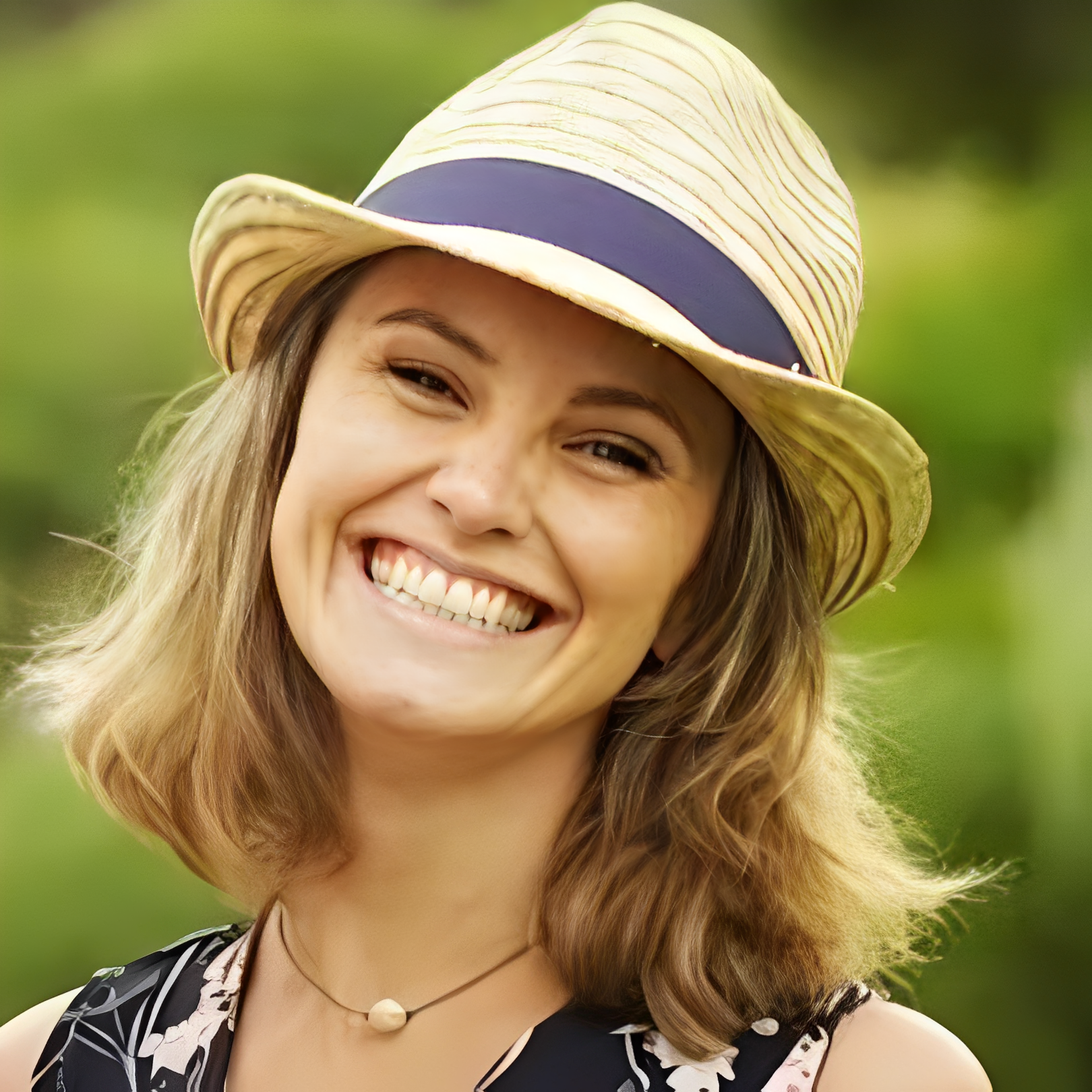 Smiling person wearing straw hat outdoors